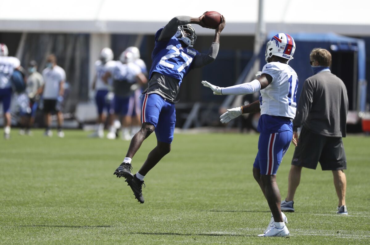 Buffalo Bills cornerback Tre'Davious White (27) intercepts the ball in front of wide receiver Stefon Diggs (14) during an NFL football training camp in Orchard Park, N.Y., Monday, Aug. 31, 2020. (James P. McCoy/Buffalo News via AP, Pool)
