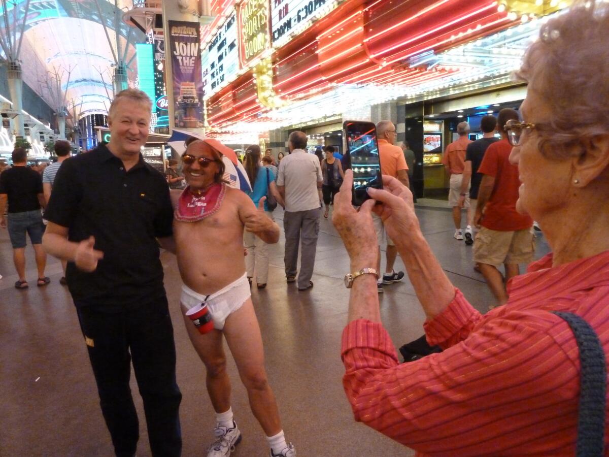 Clarice Berg of Winnebago, Minn., captures the moment as the Lost Baby, a.k.a. Gerald Morrissen, poses with her son, Jim, on Fremont Street in Las Vegas.