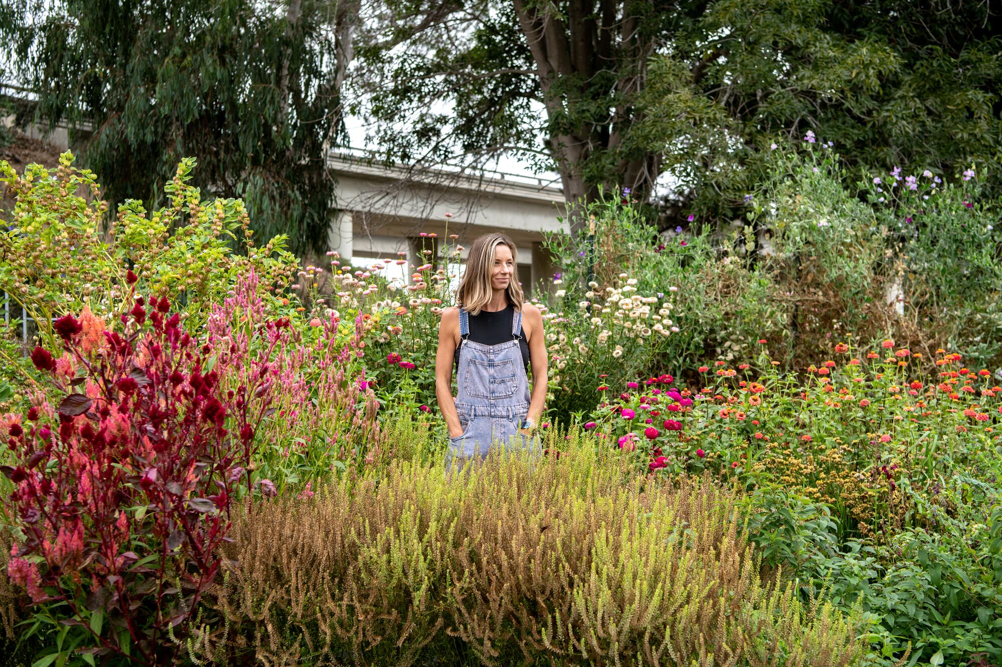 A woman stands in a flower garden