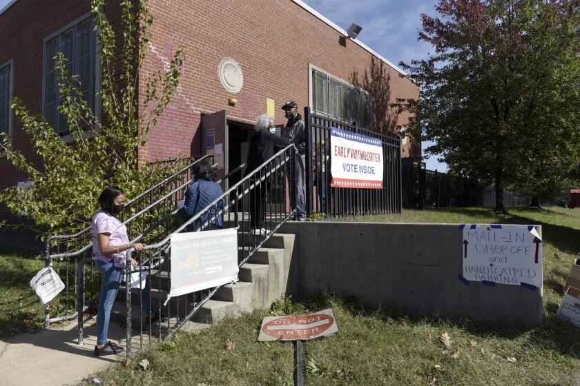 Voters line up at an early voting satellite location at the Anne B. Day elementary school, Thursday, Oct. 15, 2020, in Philadelphia. (AP Photo/Michael Perez)