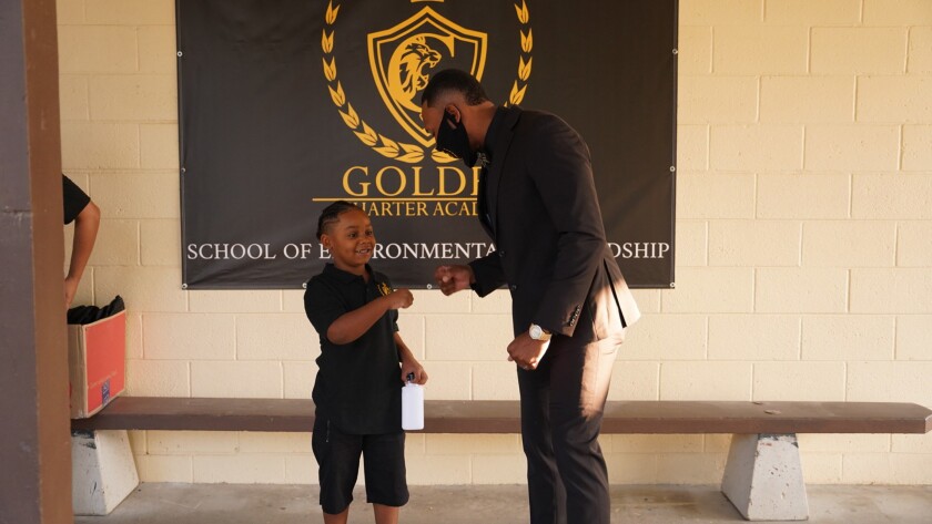Le PDG de la Golden Charter Academy, Robert Golden, partage un coup de poing avec un étudiant.
