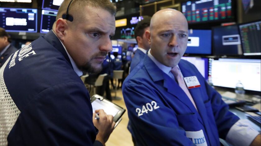 Trader Michael Milano, left, and specialist Jay Woods work on the floor of the New York Stock Exchange on Oct. 2.