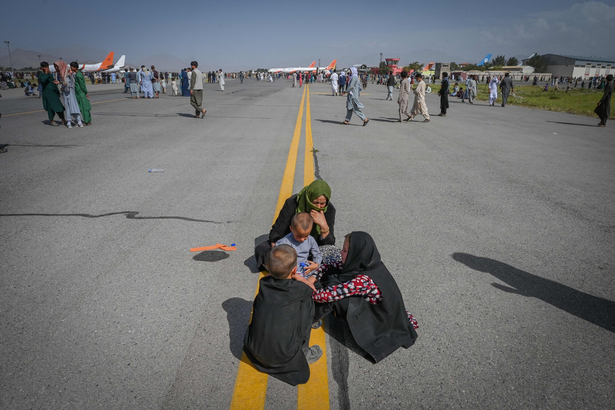Afghans sit on the tarmac