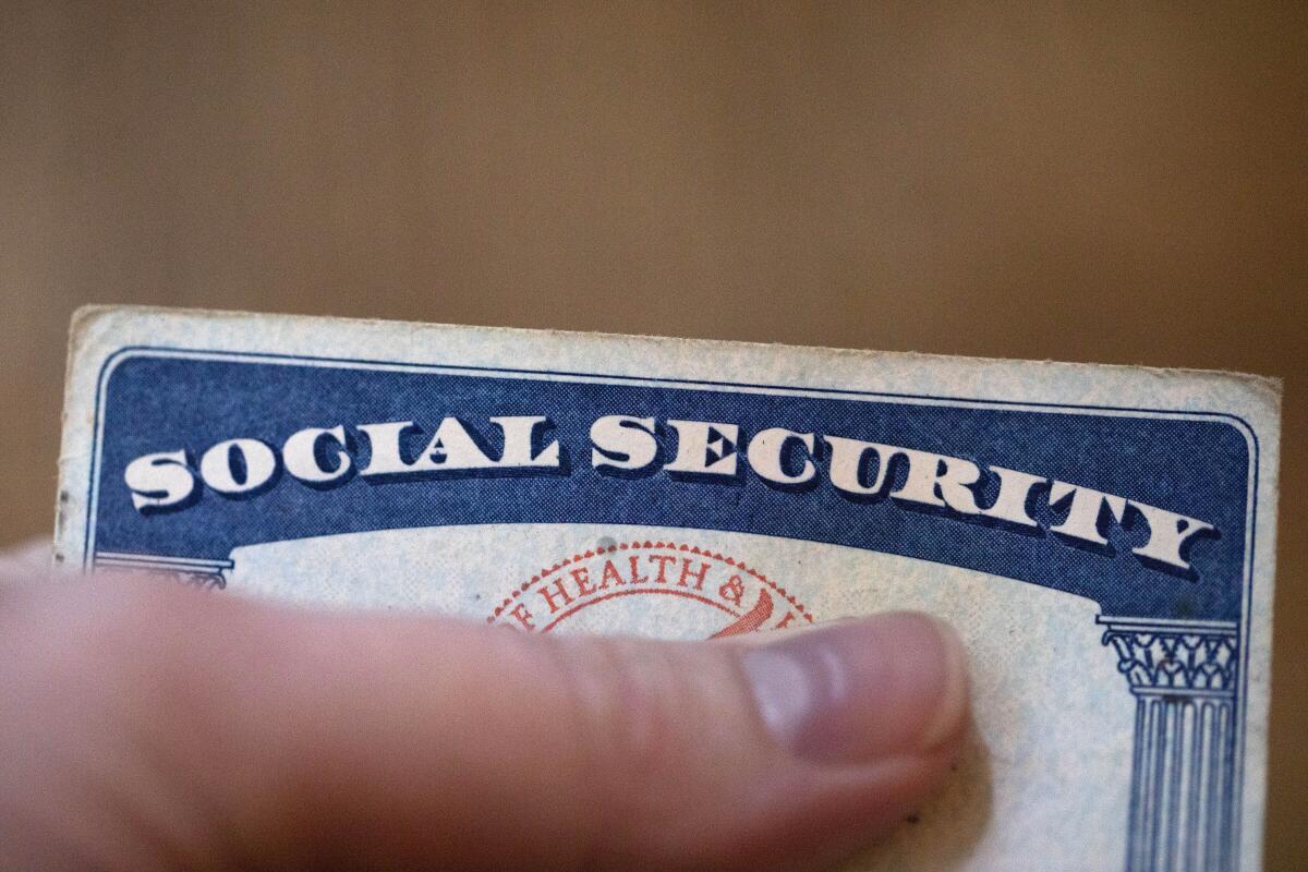 Closeup of a hand holding a Social Security card.