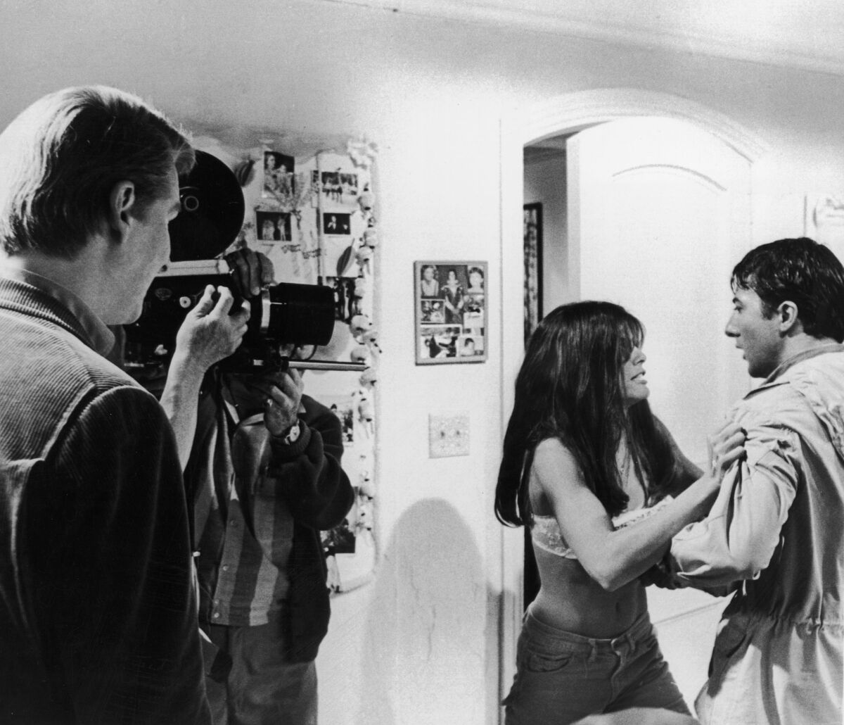 Mike Nichols directs Katharine Ross and Dustin Hoffman as a cameraman films a scene of "The Graduate" in a room.