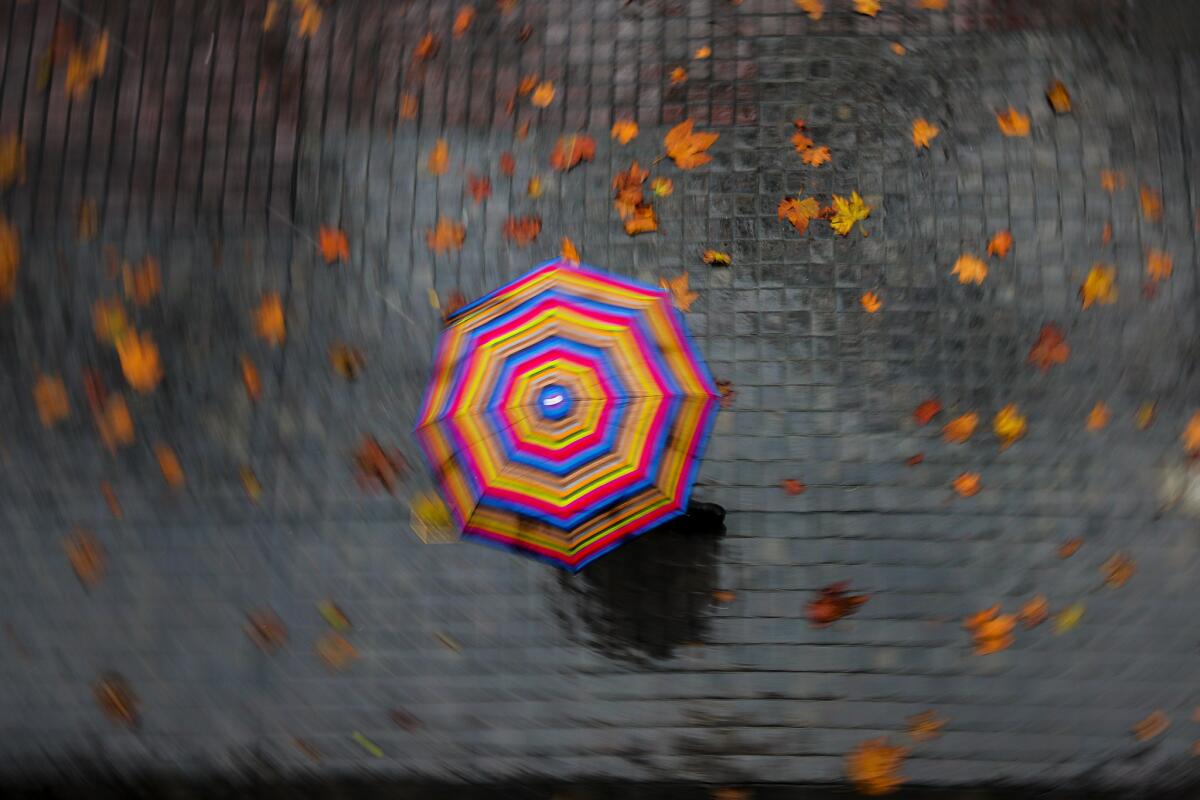 A pedestrian in downtown Los Angeles carries a colorful umbrella on Tuesday, Dec. 2.
