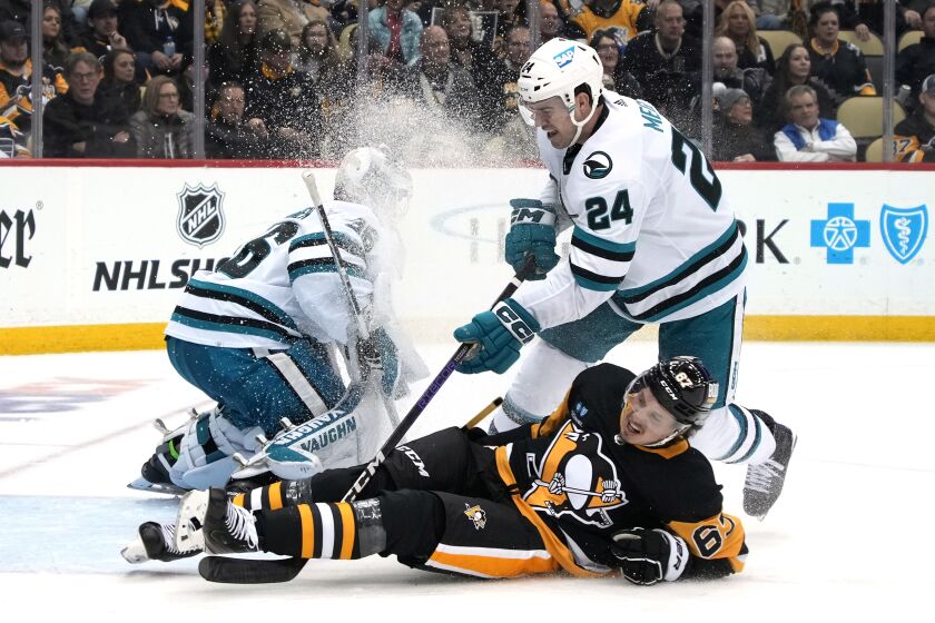 Pittsburgh Penguins' Rickard Rakell (67) is upended by San Jose Sharks' Jaycob Megna (24) during the second period of an NHL hockey game in Pittsburgh, Saturday, Jan. 28, 2023. (AP Photo/Gene J. Puskar)