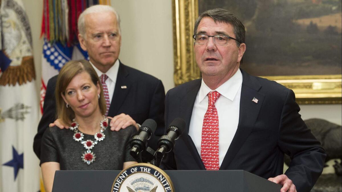Vice President Joe Biden rests his hands on the shoulders of Stephanie Carter in February 2015 at a White House event with her husband, Ashton Carter, then secretary of Defense.