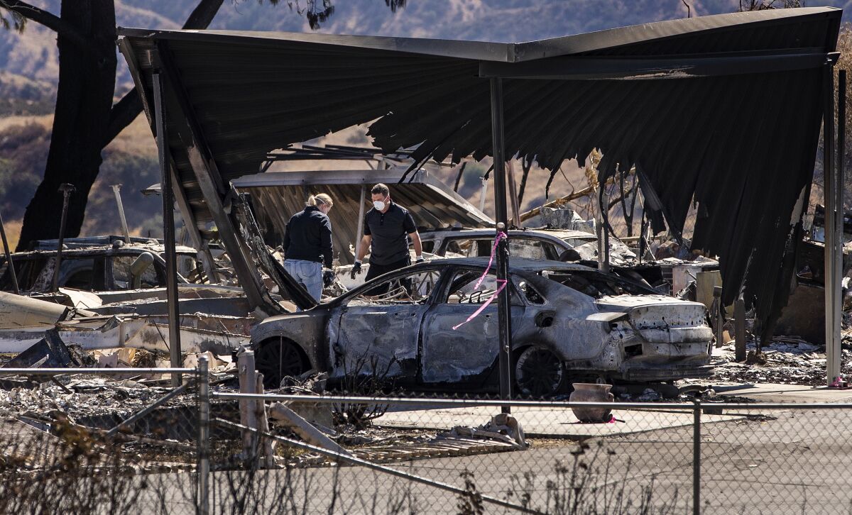 Residents sift through the rubble after the Sandalwood Fire burned many homes at the Villa Calimesa Mobile Home Park.