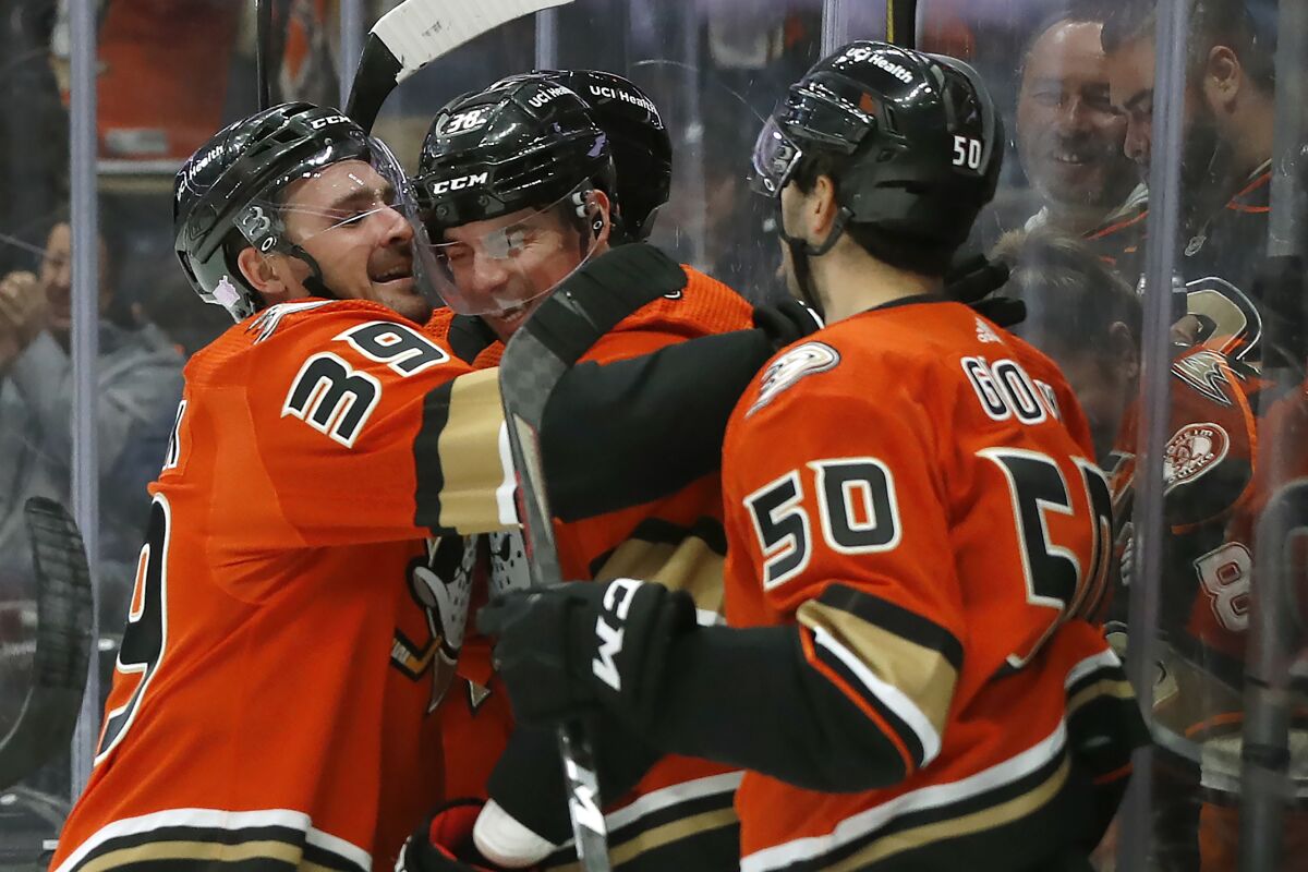 The Ducks' Sam Carrick, left, celebrates his goal with Derek Grant, center, and Benoit-Olivier Groulx on Nov. 5, 2021.