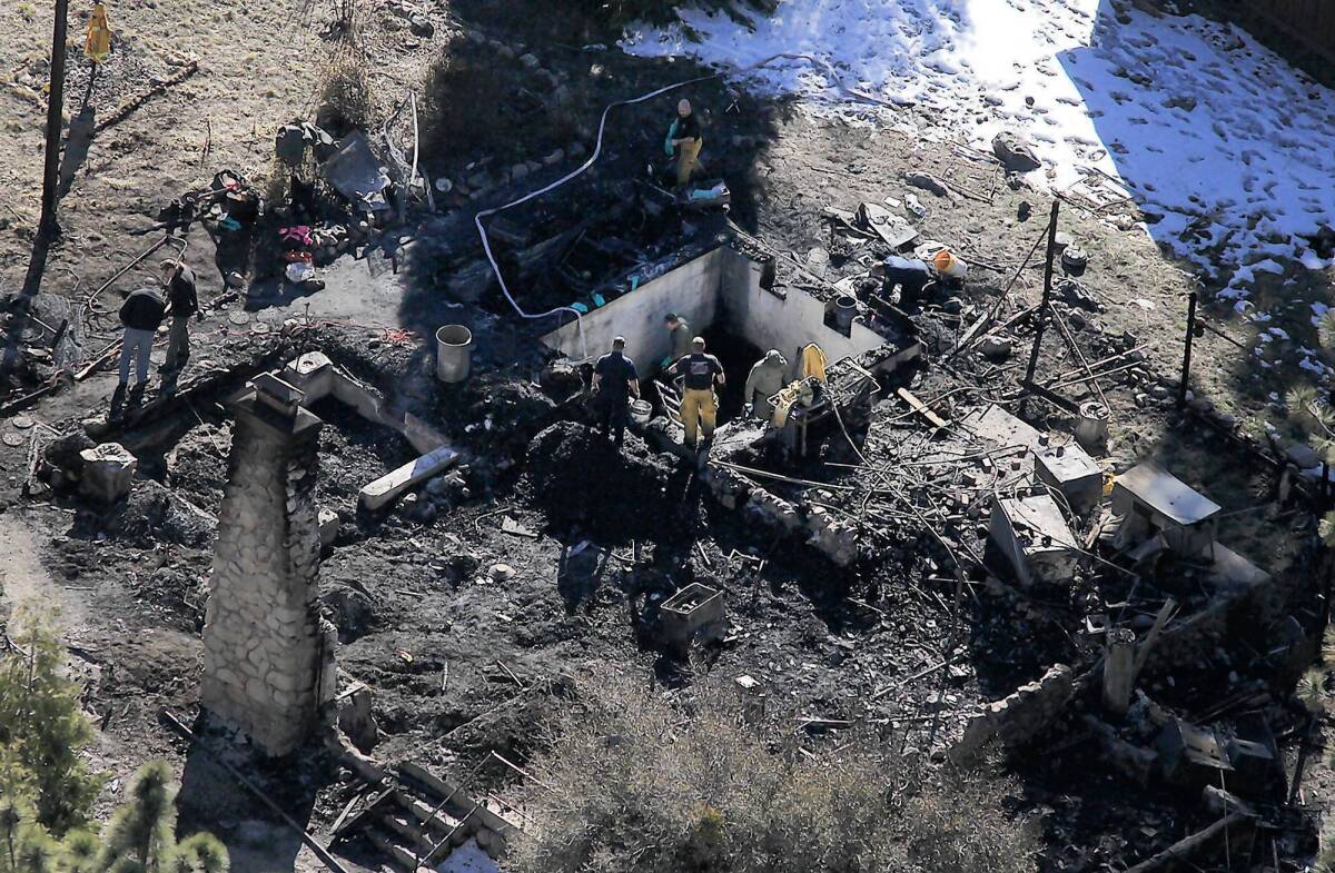 The remains of the cabin where Christopher Dorner and law enforcement officers traded fire are shown. The structure became engulfed in flames after canisters containing a powerful type of tear gas were deployed against the fugitive ex-cop inside.
