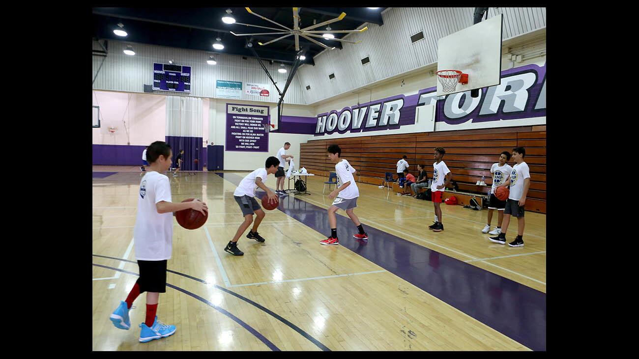 Brothers Hoops Skills Camp participants warm up prior to starting their training, at Hoover High School in Glendale on Tuesday, July 17, 2018. The basketball camp for 11 to 14-yr. olds goes through the week and is directed by HHS graduate Riley Van Patten.