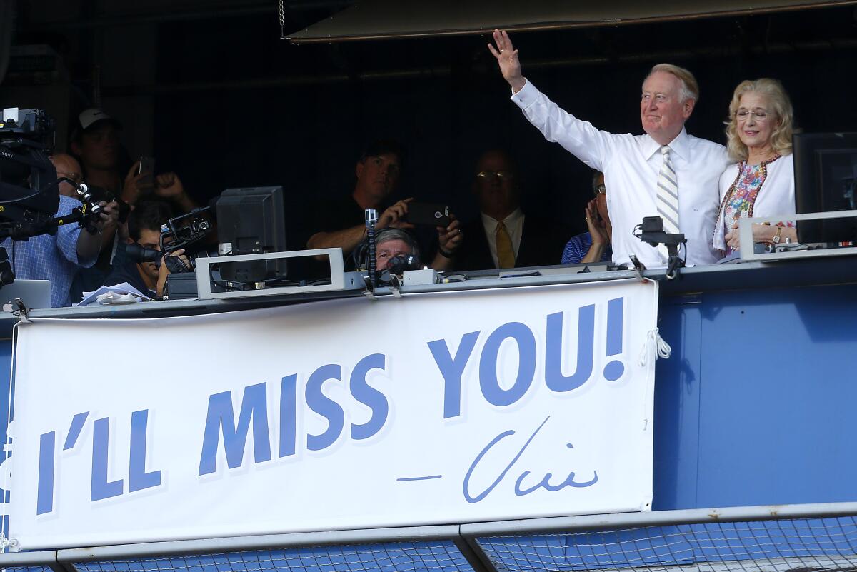 Vin Scully, with his wife Sandra Hunt, waves to the crowd after his final broadcast from Dodger Stadium on Sept. 25, 2016. 