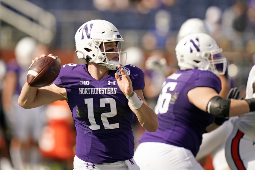 Northwestern quarterback Peyton Ramsey (12) looks for a receiver against Auburn during the first half of the Citrus Bowl NCAA college football game, Friday, Jan. 1, 2021, in Orlando, Fla. (AP Photo/John Raoux)