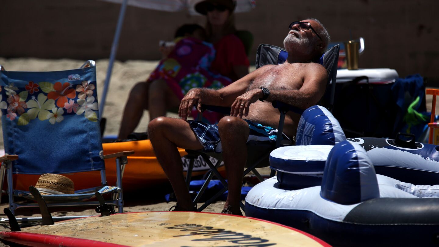 Richard Saldana, 79, of Norwalk relaxes on a hot but breezy beach day in Alamitos Bay, Long Beach