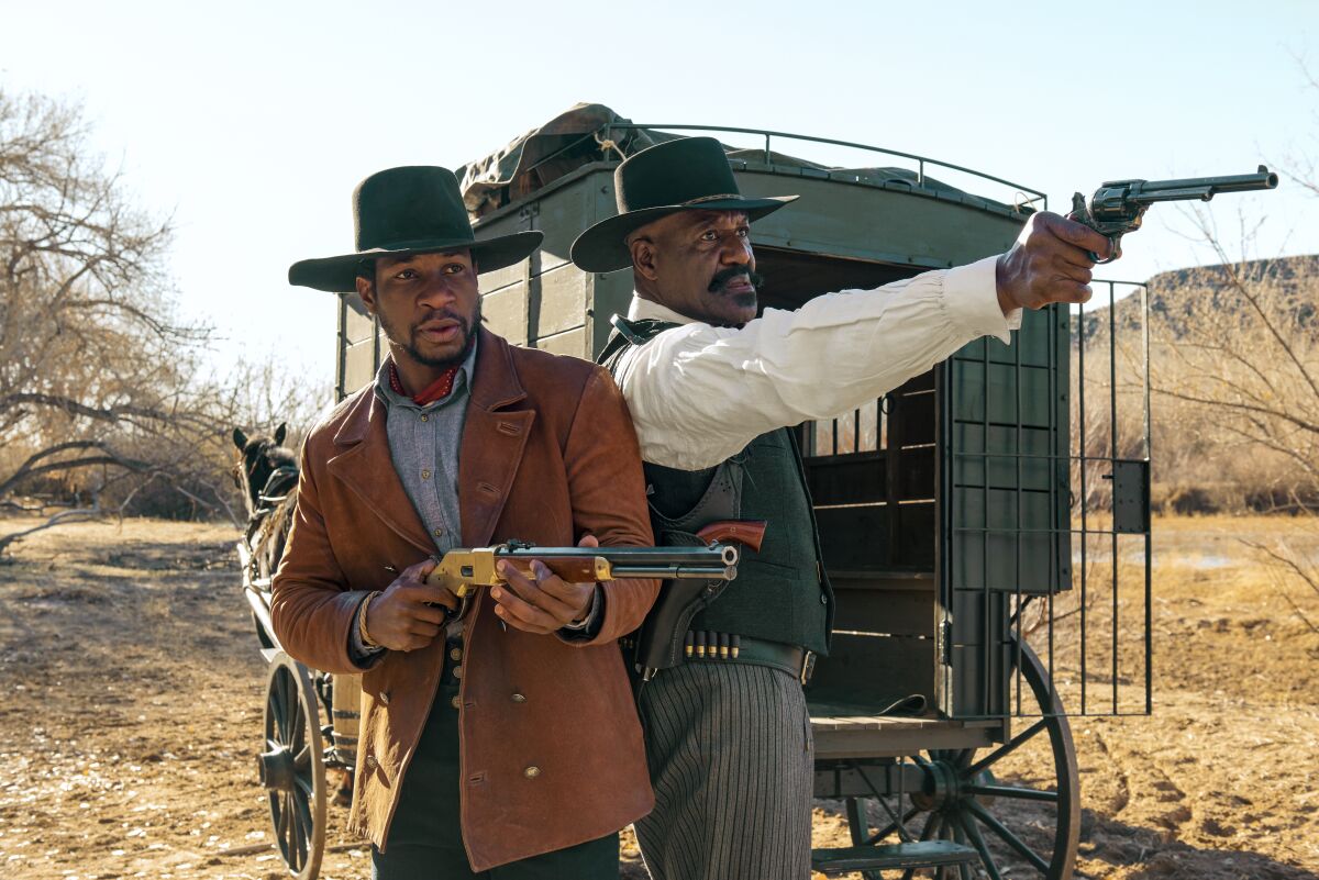 Jonathan Majors and Delroy Lindo as cowboys with guns drawn in "The Harder They Fall."