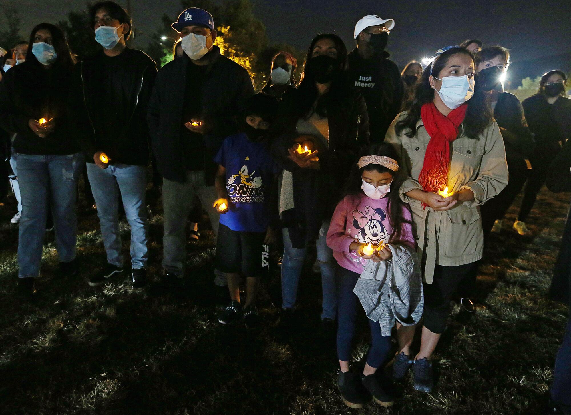 Residents in masks gather at a vigil
