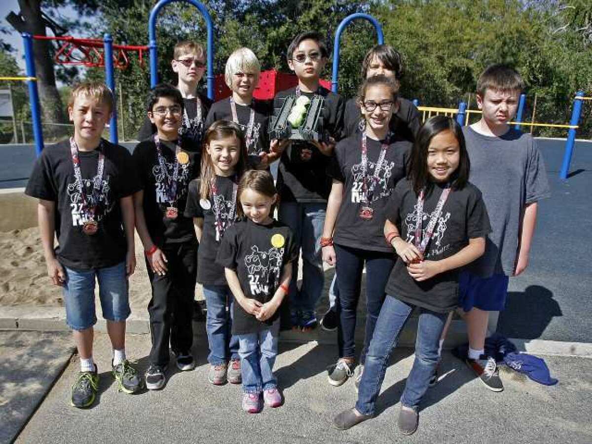 The 2% Milk robotics team pose for a group photo after they showed the entire school how their robot picks up and deposits tennis balls at Palm Crest Elementary School in La Canada Flintridge on Friday, April 26, 2013.