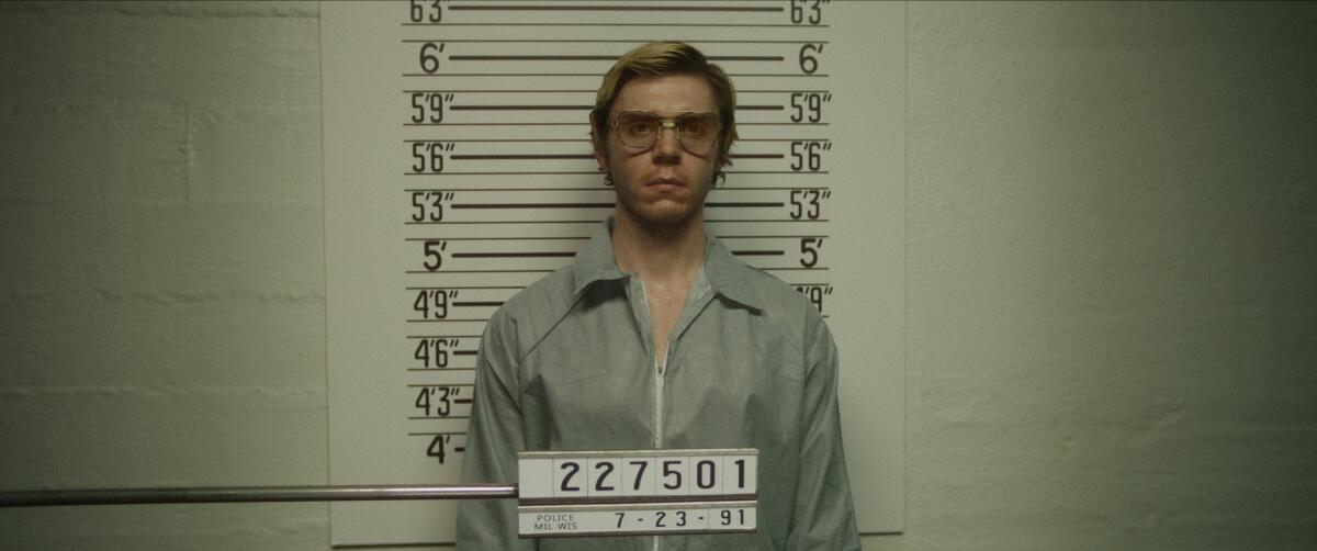 A man with blond hair in glasses standing in a jail lineup