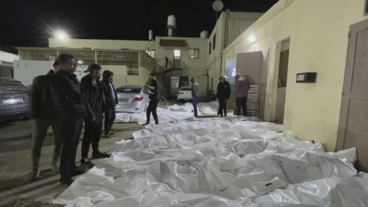 En esta imagen tomada de un video, gente mira algunos de los cuerpos llegados al hospital de Al Aqsa 