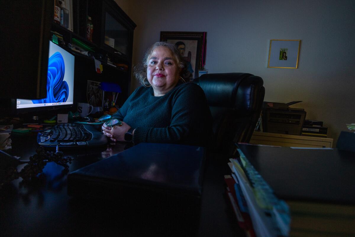 Sandra Muñoz seated at a computer in a darkened room 