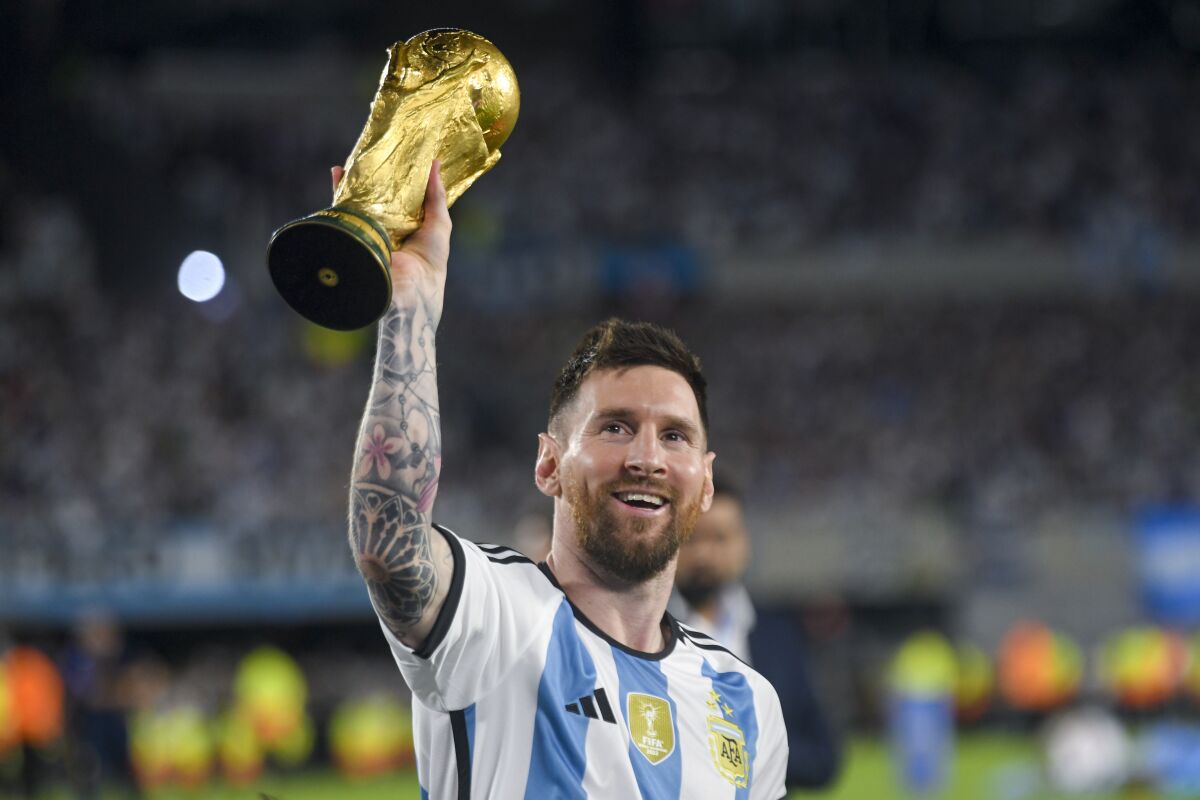 El astro argentino Lionel Messi alza la Copa Mundial durante un festejo en el amistoso contra Panamá,