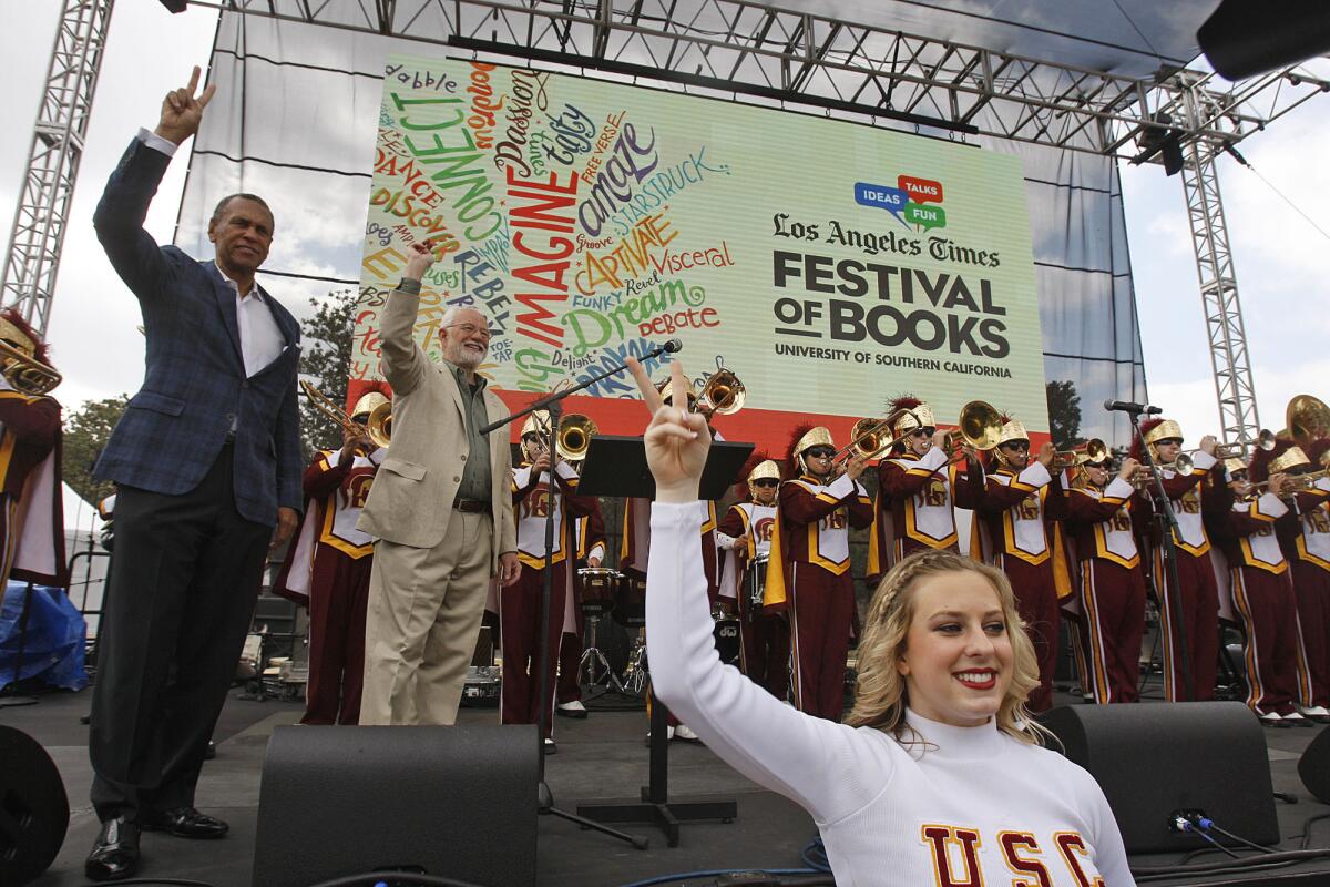 Thomas Sayles of USC, left, and Times Publisher Eddy Hartenstein join the USC band and cheerleaders at the kickoff of the L.A. Times Festival of Books on Saturday on the USC campus.