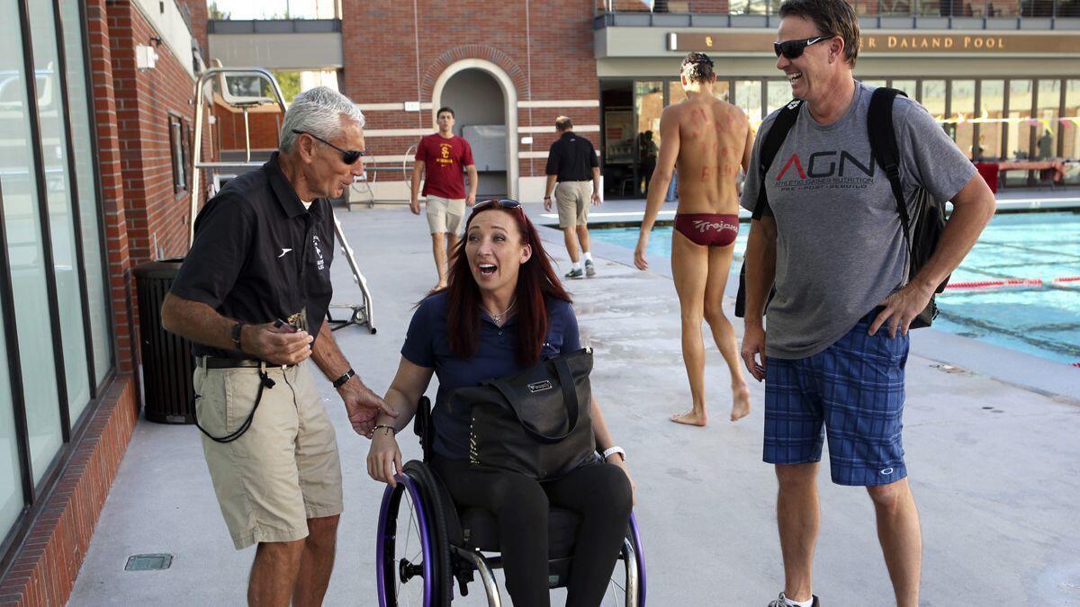 Jon Urbanchek, left, a volunteer coach for the USC swim team, greets Amy Van Dyken, a six-time Olympic gold medalist who was later paralyzed in an ATV accident, in 2015.