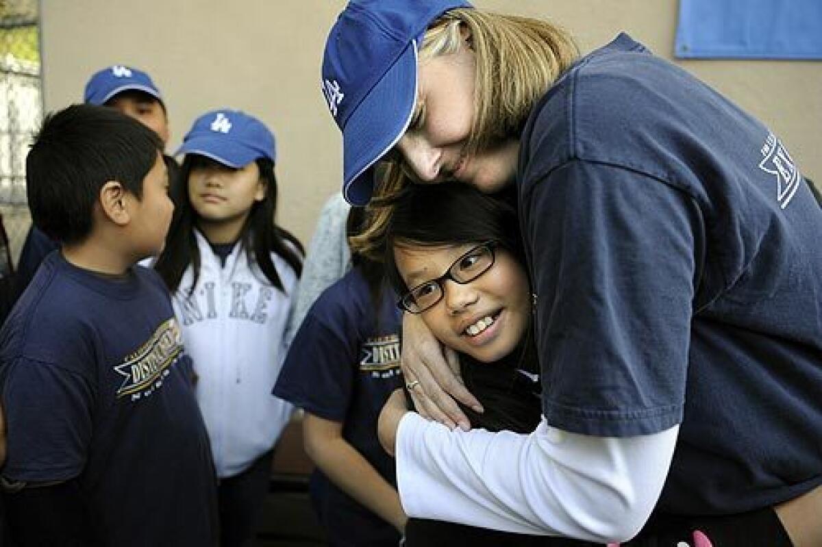 Fourth-grade teacher Shannon Garrison, 34, at Solano Avenue Elementary near Chinatown hugs student Kelly Gong after receiving the Milken Family Foundation award of $25,000 for her exceptional work as an educator. She was one of two Los Angeles Unified teachers awarded the honor Thursday by the Santa Monica-based foundation. Literacy coach and coordinator Dana Stephens, 43, of Colfax Elementary in North Hollywood was also recognized.