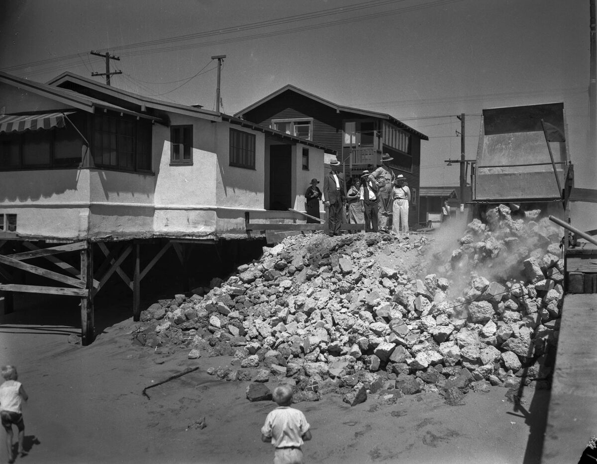 Sep. 6, 1934: In Newport Beach, where the foot of 26th Street was washed away, truckloads of rock were dumped in an attempt to prevent further destruction by pounding waves.