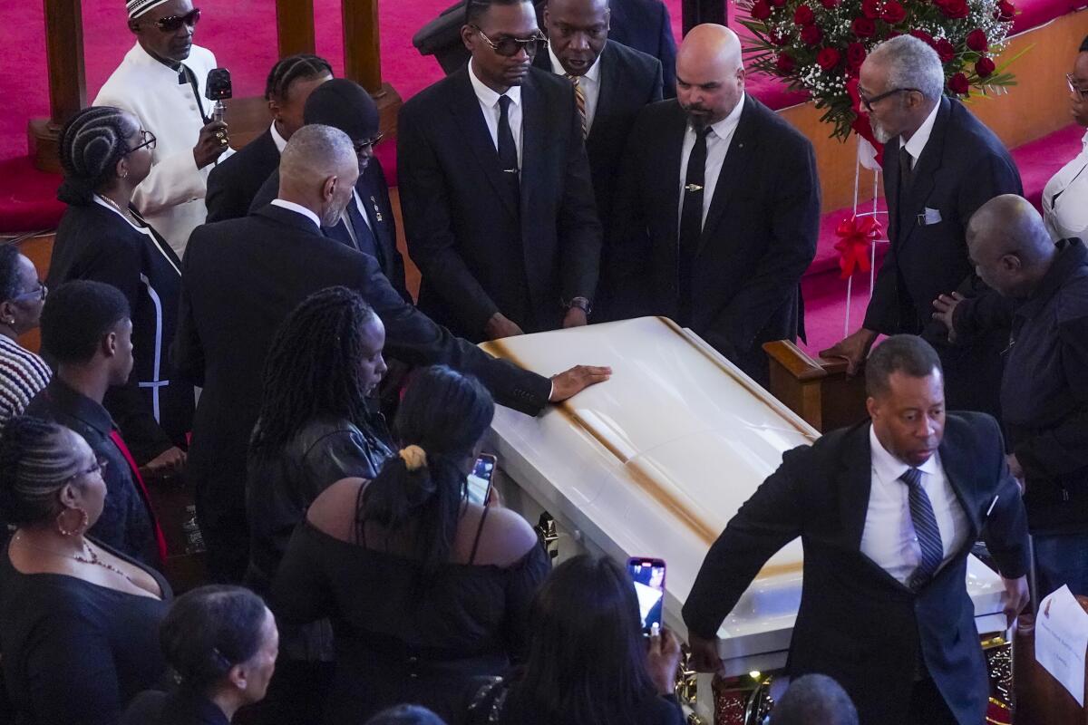 Andre Zachery, father of Jordan Neely, places his hand on Neely's casket