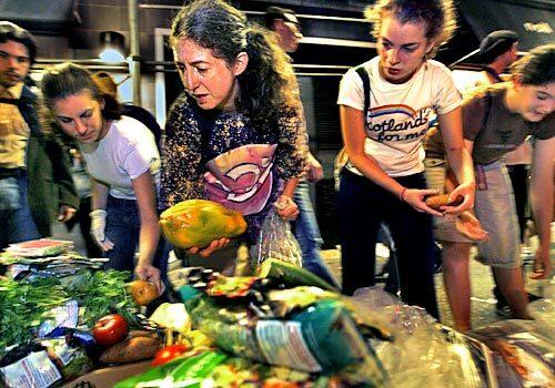 Janet Kalish, center, with a papaya she collected during a New York City trash tour for people interested in becoming freegans -- anti-consumerists who, in the words of one advocate, are "opting out of capitalism in any way that we can."