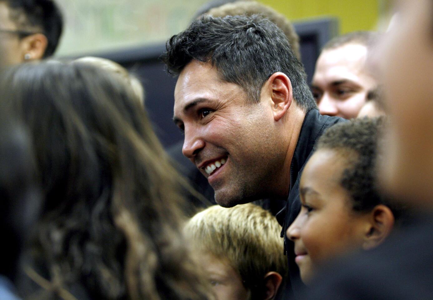 Ten-time World Champion boxer Oscar de la Hoya poses with children for a photo at the Boys and Girls Club of Burbank and Greater East Valley for an AT&T press conference.