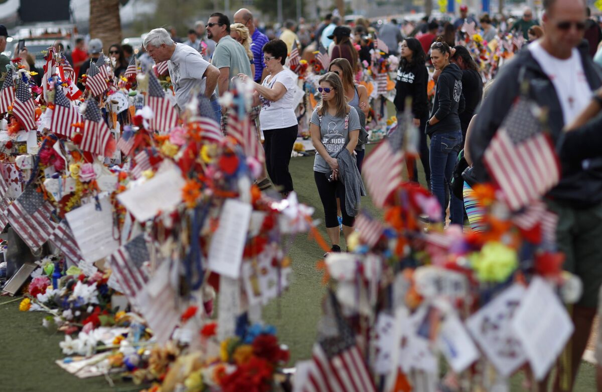 FILE - People visit a makeshift memorial honoring the victims of the Oct. 1, 2017, mass shooting in Las Vegas, on Nov. 12, 2017. Five years after a gunman killed 58 people and wounded hundreds more at a country music festival in Las Vegas, in the deadliest mass shooting in modern U.S. history, the massacre is now part of a horrifying increase in the number of mass slayings with more than 20 victims, according to a database of mass killings maintained by The Associated Press, USA Today and Northeastern University. (AP Photo/John Locher, File)