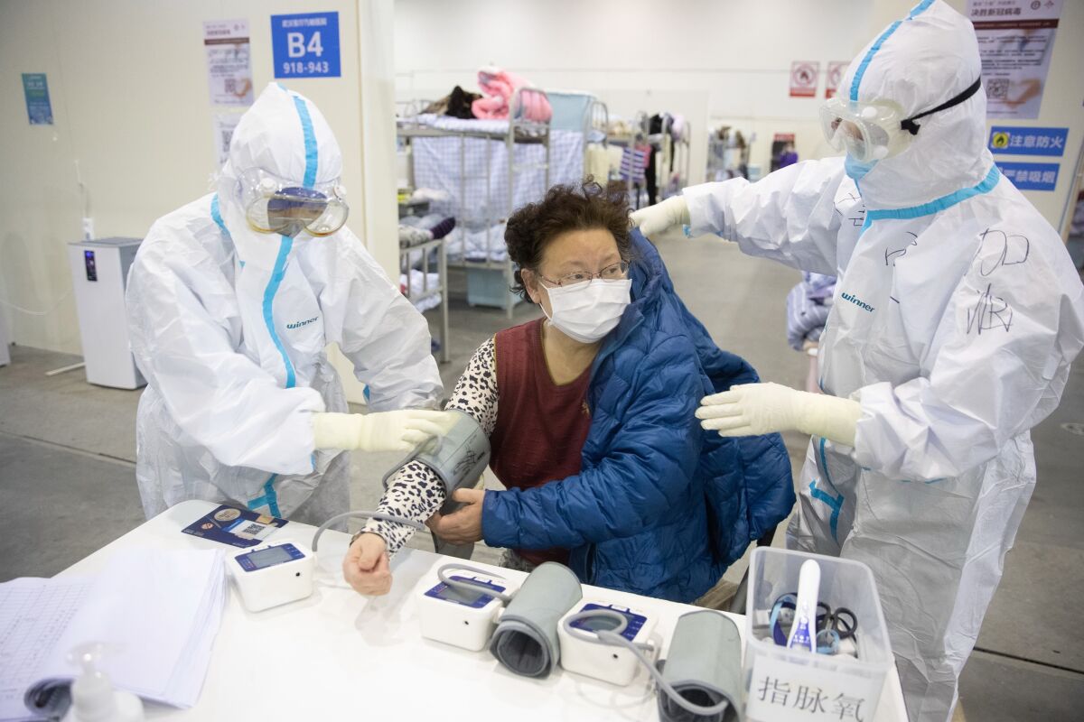 Personal médico en trajes protectores atiende a los pacientes del hospital improvisado de Wuhan Fang Cang en Wuhan, provincia de Hubei (China), 17 de febrero de 2020.