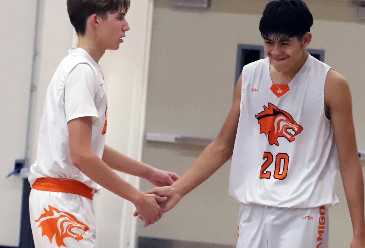 Los Amigos' Philip Steiner (4) and Ricardo Toledo (20) shake hands after a foul is called on Loara on Friday night.