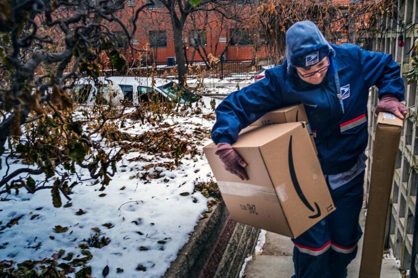 United States Postal Service worker Missie Kittok, who has been a letter carrier for 15 months, helps deliver some packages in time for Christmas in Minneapolis, Sunday, Dec. 24, 2017. (Richard Tsong-Taatarii/Star Tribune via AP)