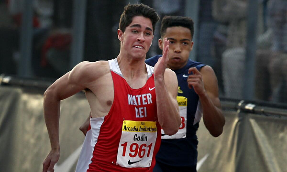 Mater Dei's Curtis Godin, left, speeds past Santa Monica's Marcel Espinoza on his way to winning the boys' 100 meters Saturday at the Arcadia Invitational.