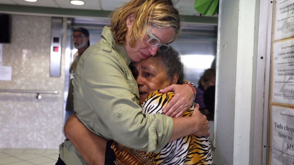 Mayor Carmen Yulin Cruz (L) hugs a woman while visiting a home in San Juan, Puerto Rico.