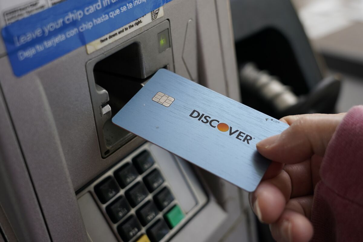 A consumer uses a Discover card in Madison, Miss., Thursday, July 1, 2021. In 2021, dedicate a financial account to goods, services and activities that bring you joy. Perhaps this fund would cover monthly massages or weekly smoothies, or it could be used to save up for a vacation. (AP Photo/Rogelio V. Solis)