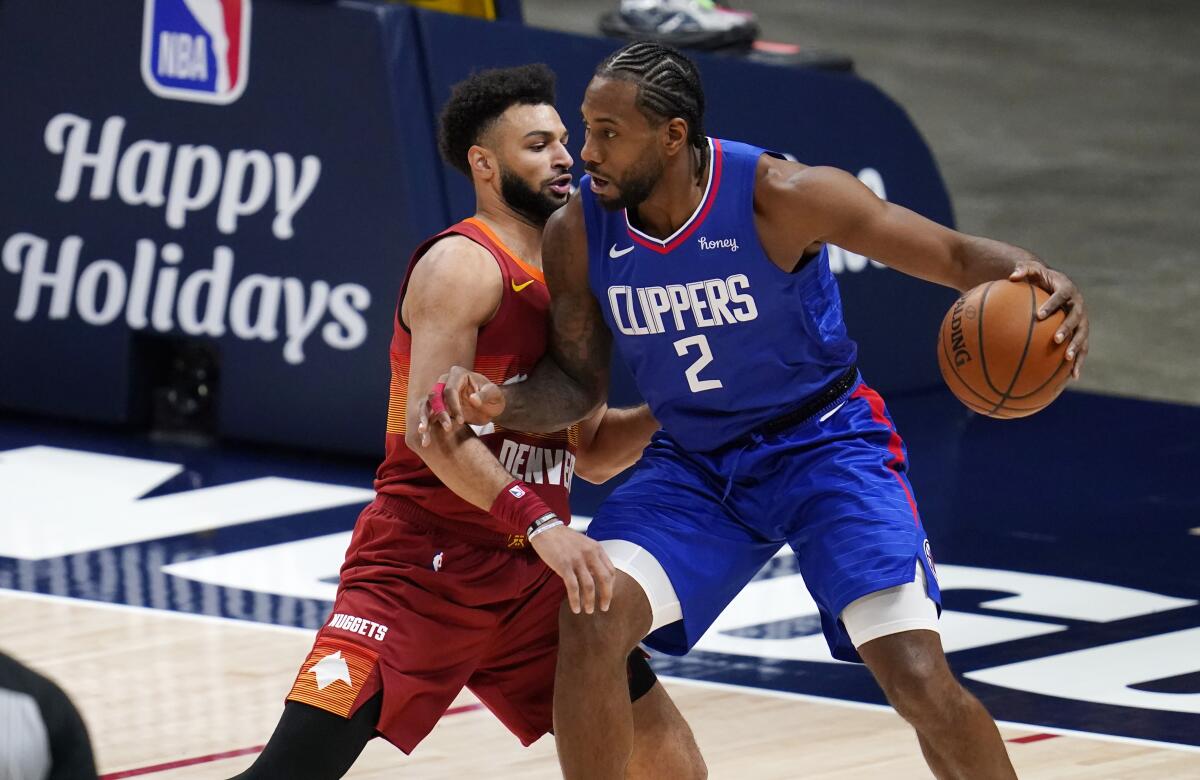 Clippers forward Kawhi Leonard drives against Nuggets guard Jamal Murray.