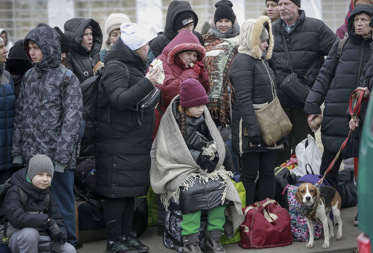 People who left Ukraine, wait for a bus to take them to the train station in Przemysl, at the border crossing in Medyka, Poland, Friday, March 4, 2022. More than 1 million people have fled Ukraine following Russia's invasion in the swiftest refugee exodus in this century, the United Nations said Thursday. (AP Photo/Visar Kryeziu)