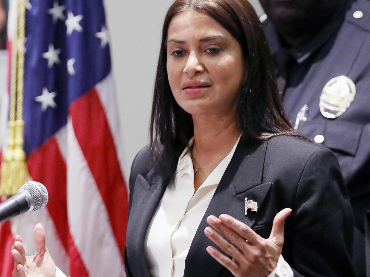 A woman speaks at a microphone.