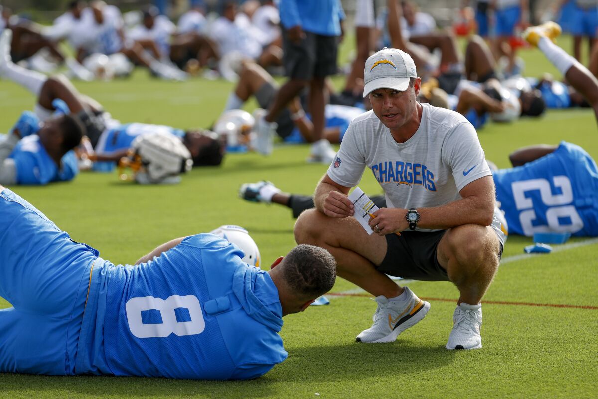Chargers head coach Brandon Staley (right) talks to linebacker Kyle Van Noy (8) at camp.