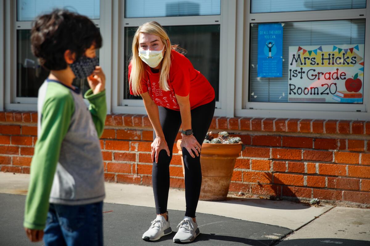 A first-grade teacher speaks with her student