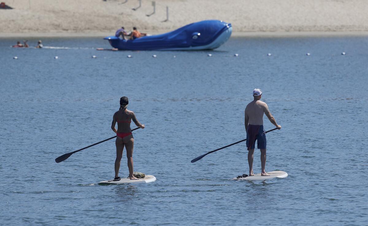 Paddleboarders at the Newport Dunes Wednesday, two days into a heatwave expected to bring extreme conditions through Monday.
