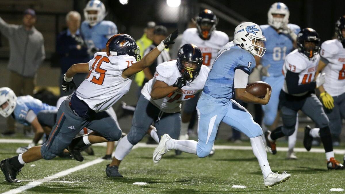 Corona del Mar's Nathaniel Espinoza breaks away from Eastvale Roosevelt's Austin Marin (75) and runs for a touchdown in the first round of the CIF Southern Section Division 4 playoffs on Nov. 10, 2017.