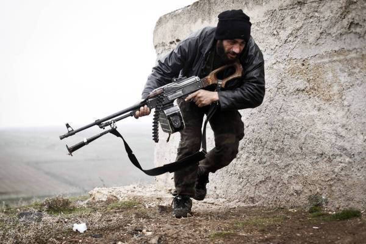 A Syrian opposition fighter takes cover during fighting in Azaz.