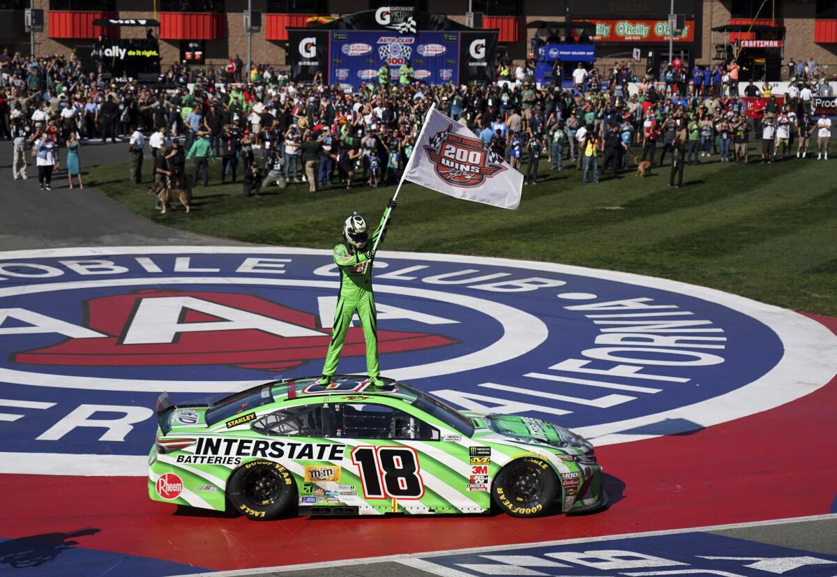 Kyle Buschs stands on his car after winning the NASCAR Cup Series race at Auto Club Speedway in Fontana on March 17, 2019.