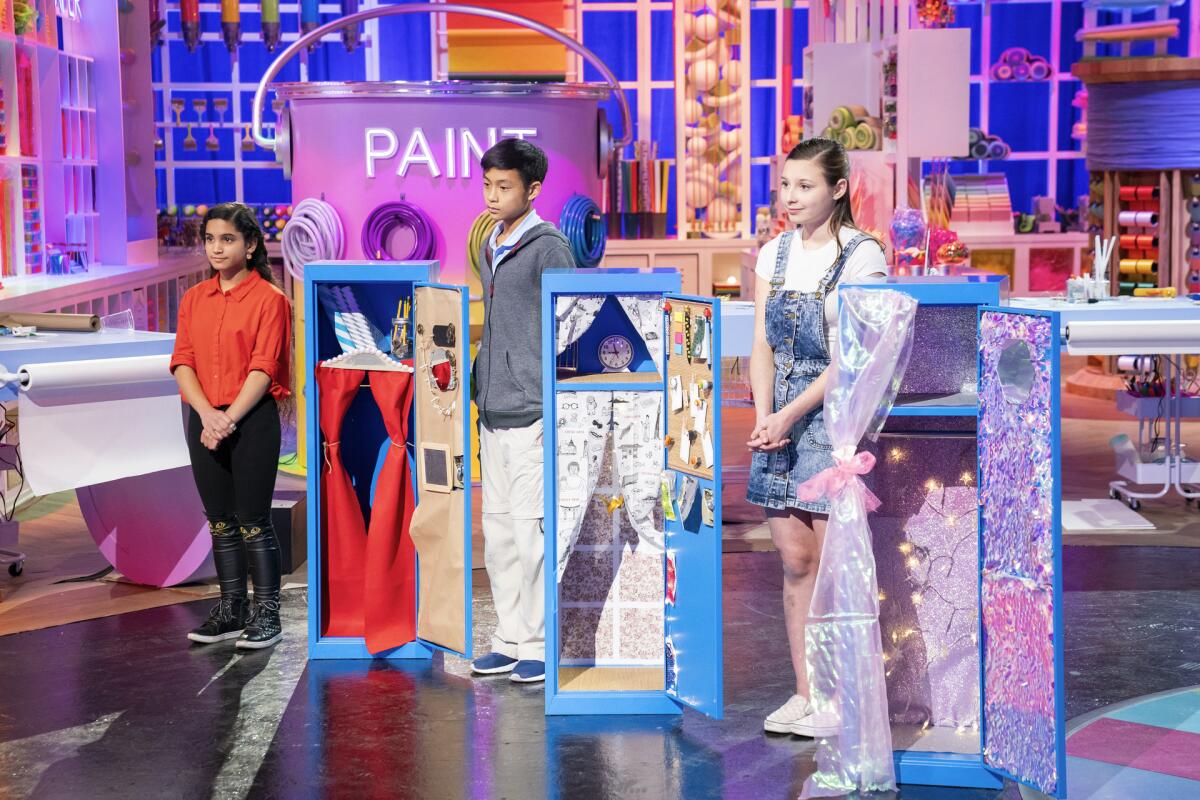 Three young crafters display their elaborate locker designs on a reality show set